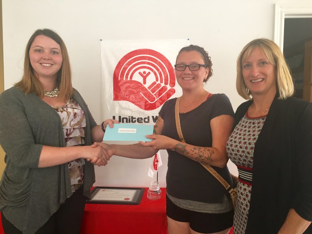 Brittany Burley accepts the donation from Crystal and Dena of Fanshawe Student Union.